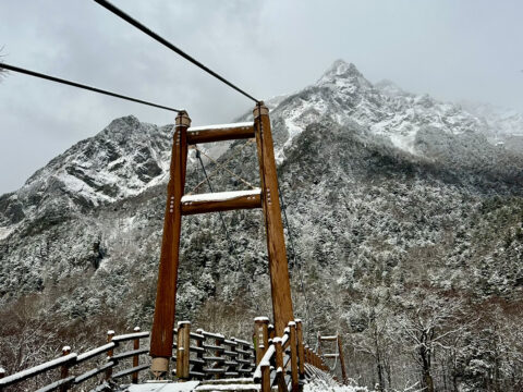 雪に覆われた明神岳と明神橋